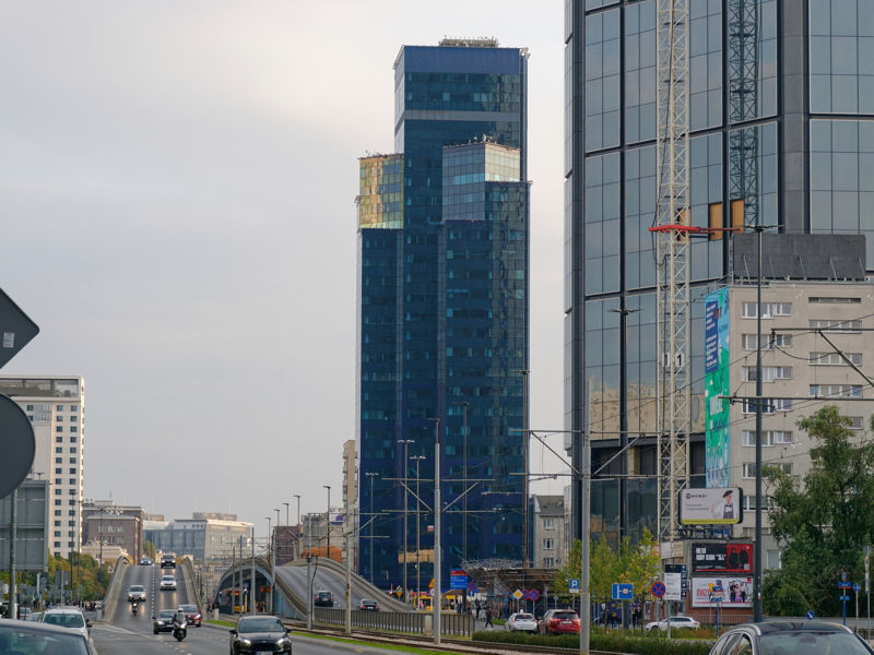 13 - A street-level view of urban buildings in Warsaw including the blue skyscraper Central Tower
